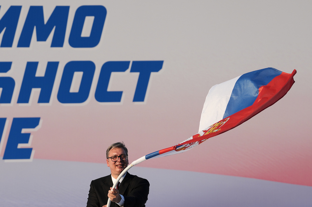 Serbian President Aleksandar Vucic waves a Serbian flag during a rally of the ruling Serbian Progressive Party (SNS) in Belgrade, Serbia, Saturday, June 27, 2026, where he announced that he will resign in the coming weeks. (AP Photo/Darko Vojinovic)