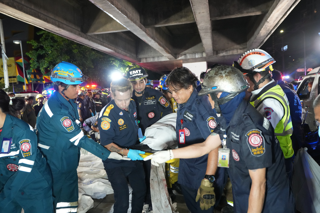 Rescuers carry the body of a victim of a fire in Bangkok, Thailand, Monday, July 13, 2026. (AP Photo/Sakchai Lalit)