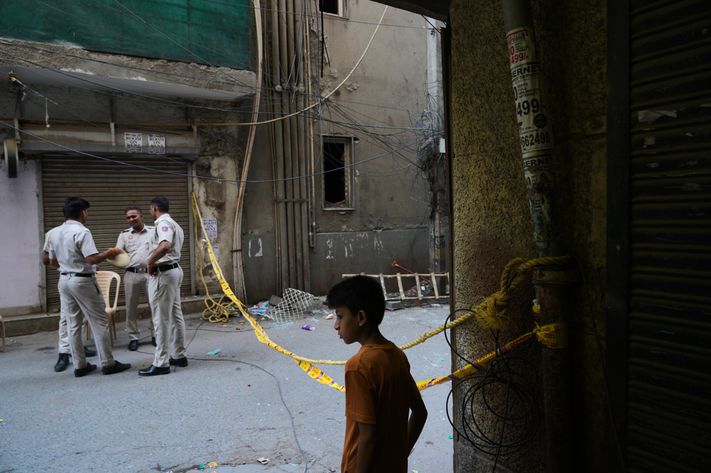 Policemen guard in front of a restaurant and hotel building that caught fire Wednesday, in New Delhi, India, Thursday, June 4, 2026. (AP Photo/Manish Swarup)