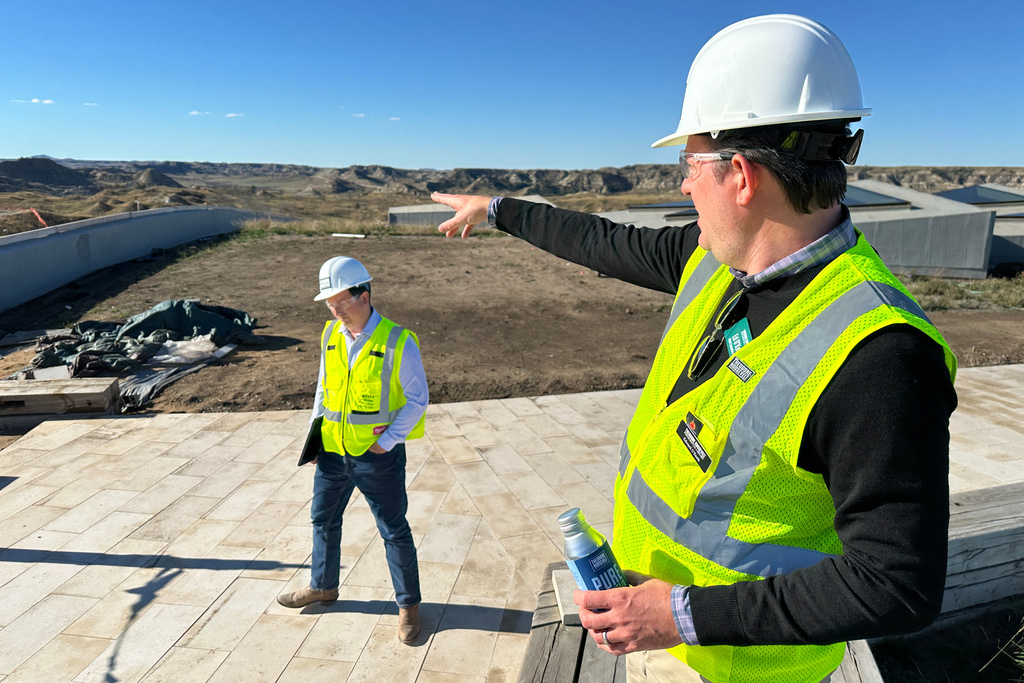 Theodore Roosevelt Presidential Library Foundation CEO Ed O'Keefe, right, points to the distance atop the roof of the library Tuesday, Oct. 7, 2025, near Medora, N.D. Seen at left is Foundation Chief Communications Officer Matt Briney. (AP Photo/Jack Dura)