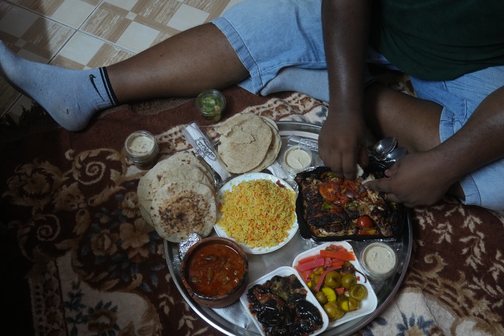 Egyptian wrestler Ashraf Mahrous, better known as Kabonga, eats his lunch meal at his home in Cairo, Egypt, July 24, 2025. (AP Photo/Amr Nabil)