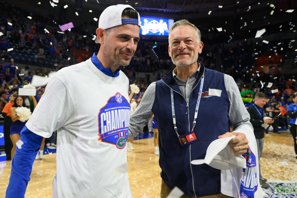 Florida head coach Todd Golden and athletics director Scott Stricklin celebrate Florida's SEC regular season title after an NCAA college basketball game against Arkansas, Saturday, Feb. 28, 2026, in Gainesville, Fla. (AP Photo/Noah Lantor)