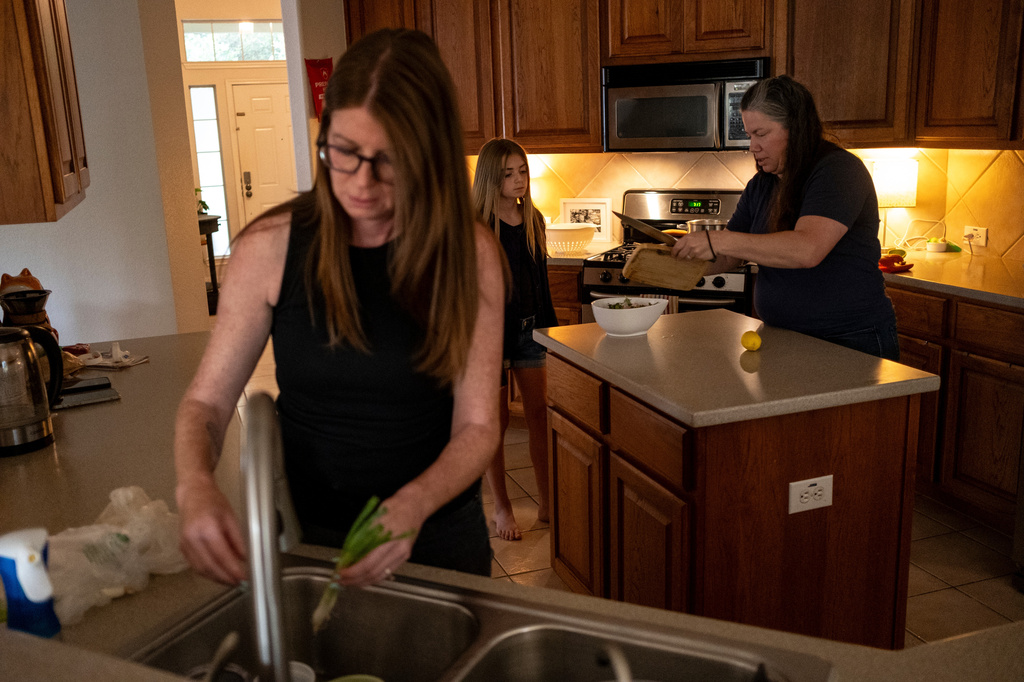 Jessica Edgar-Corum, her daughter Ivy Edgar, 10, and wife Jamie Corum prepare dinner at their home on Monday, June 29, 2026, in Pflugerville, Texas. (AP Photo/Joel Angel Juarez)