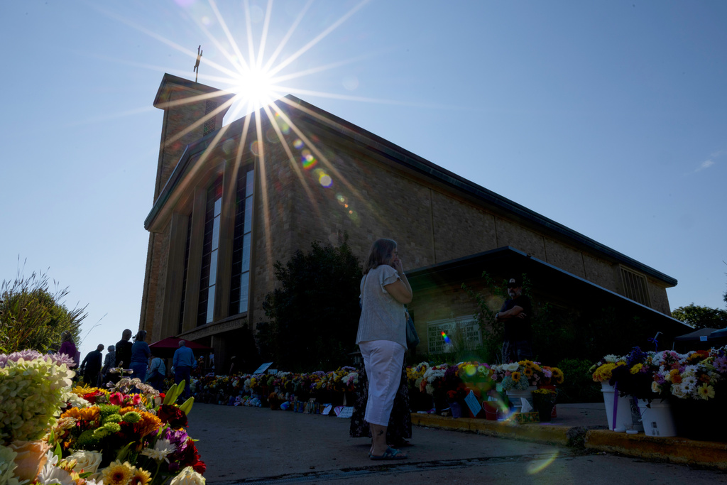 The sun shines over the memorial outside Annunciation Catholic Church during Mass after Wednesday's shooting, Sunday, Aug. 31, 2025, in Minneapolis.(AP Photo/Ellen Schmidt)