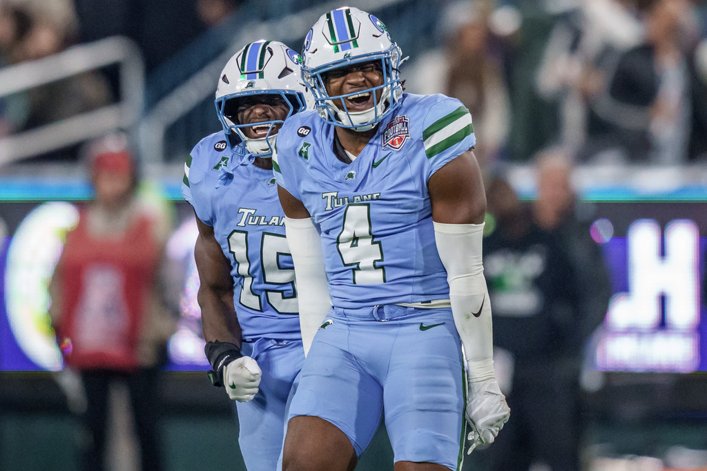 Tulane linebacker Chris Rodgers (4) reacts after a tackle with Tulane wide receiver Zycarl Lewis Jr. (15) during the second half of the American Conference championship NCAA college football game against North Texas in New Orleans, Friday, Dec. 5, 2025. (AP Photo/Matthew Hinton)