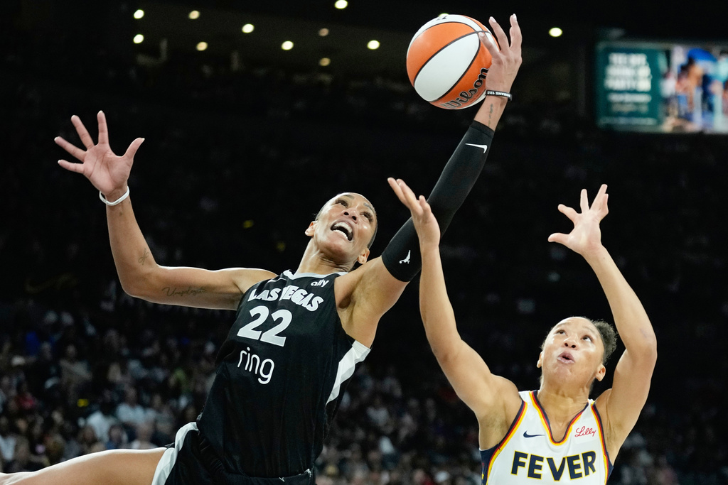FILE - Las Vegas Aces center A'ja Wilson (22) grabs a rebound over Indiana Fever guard Aerial Powers (23) during the second half of Game 2 of a WNBA basketball playoff semifinals series Tuesday, Sept. 23, 2025, in Las Vegas. (AP Photo/John Locher, File)