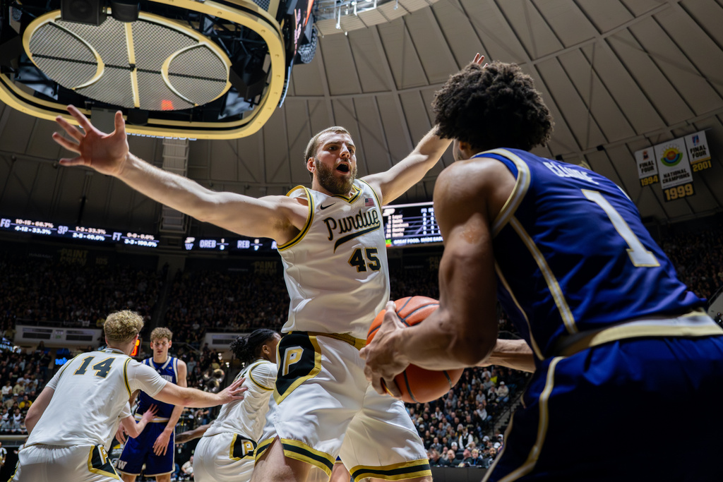 Purdue center Oscar Cluff (45) defends Washington guard Desmond Claude (1) as he in-bounds the ball during the first half of an NCAA college basketball game, Wednesday, Jan. 7, 2026, in West Lafayette, Ind. (AP Photo/Doug McSchooler)