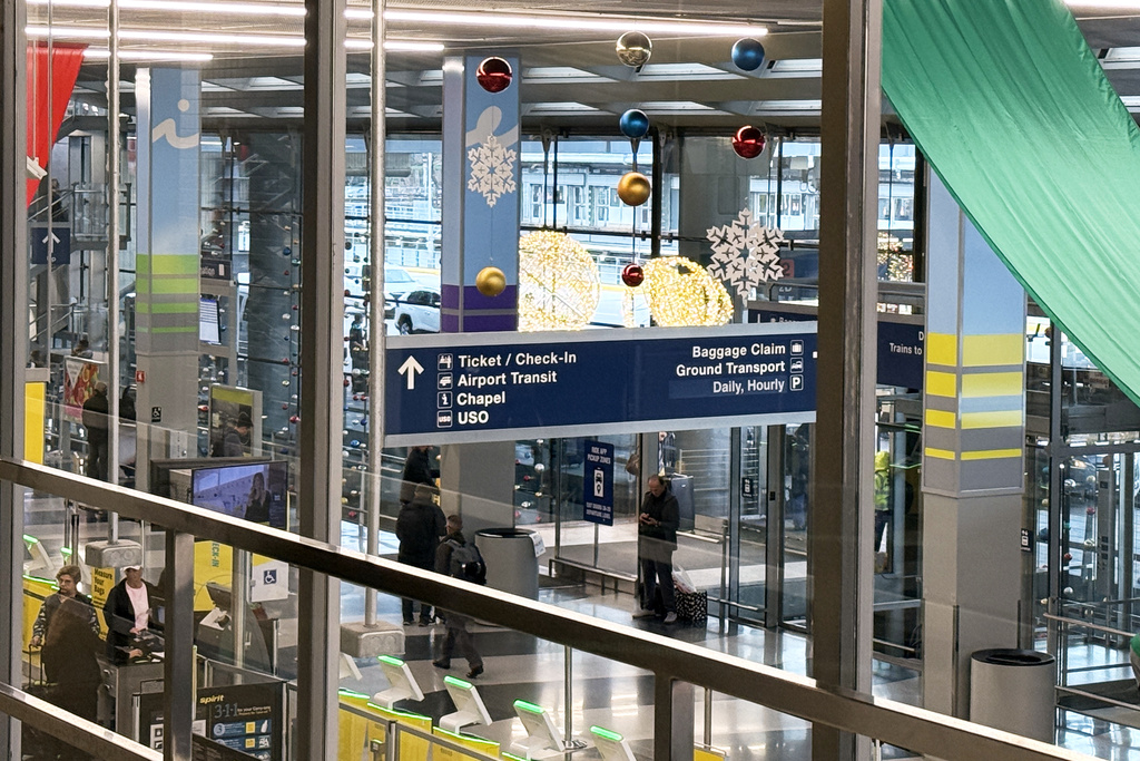 A sign points the way to the interfaith chapel where regular Catholic, Muslim and Protestant services are held at O'Hare International Airport, in Chicago, Monday, Nov. 17, 2025. (AP Photo/Giovanna Dell'Orto)
