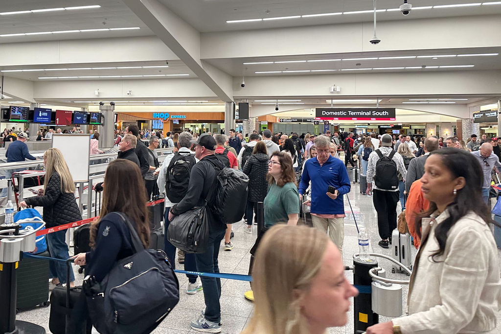 Travelers stand in a TSA checkpoint line at Hartsfield–Jackson Atlanta International Airport on Friday, March 27, 2026. (AP Photo/Emilie Megnien)