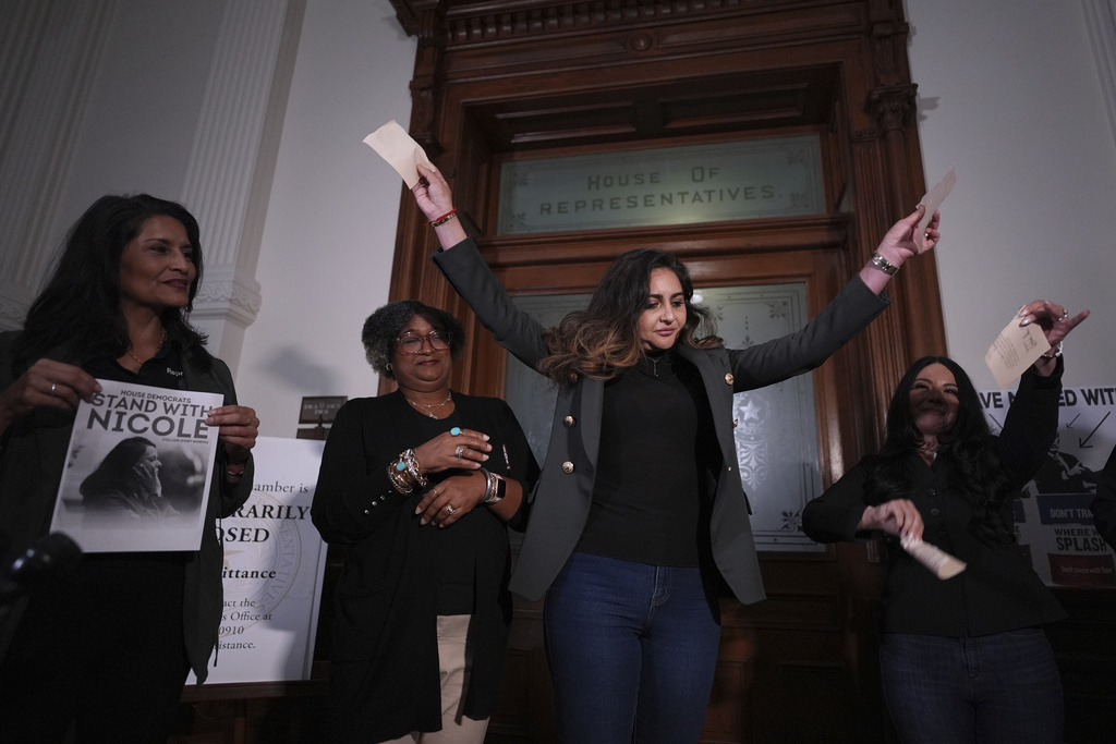 Democratic Texas state Rep. Mihaela Plesa, center, and Rep. Cassandra Garcia Hernandez, right, tear up their 'permission slips' outside of the House Chamber as they plan to join fellow Rep. Nicole Collier who refuses to leave due to a required law enforcement escort, Tuesday, Aug. 19, 2025, in Austin, Texas. (AP Photo/Eric Gay)