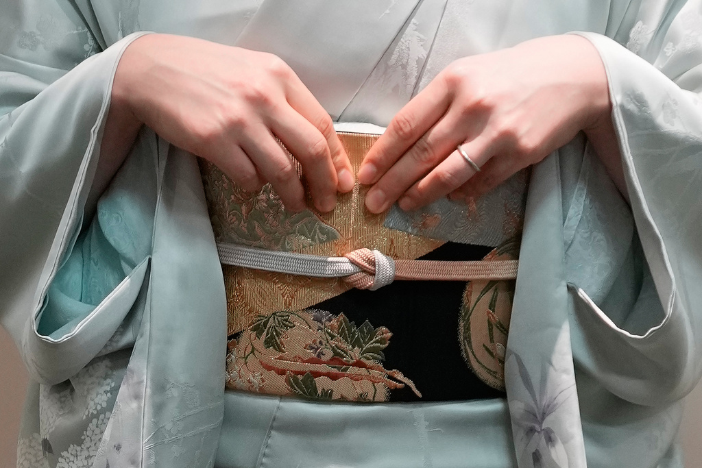 A woman displays a kimono in Tokyo Tuesday, Nov. 11, 2025. (AP Photo/Eugene Hoshiko)