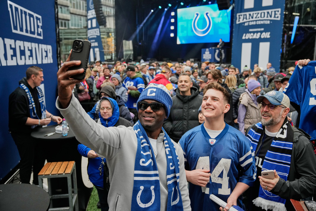 Former Indianapolis Colts running back Edgerrin James takes a selfie with fans at Das Center in Potsdamer Platz in Berlin Germany, Saturday, Nov. 8, 2025, ahead of Sunday's NFL football game against the Atlanta Falcons. (AP Photo/Ebrahim Noroozi)