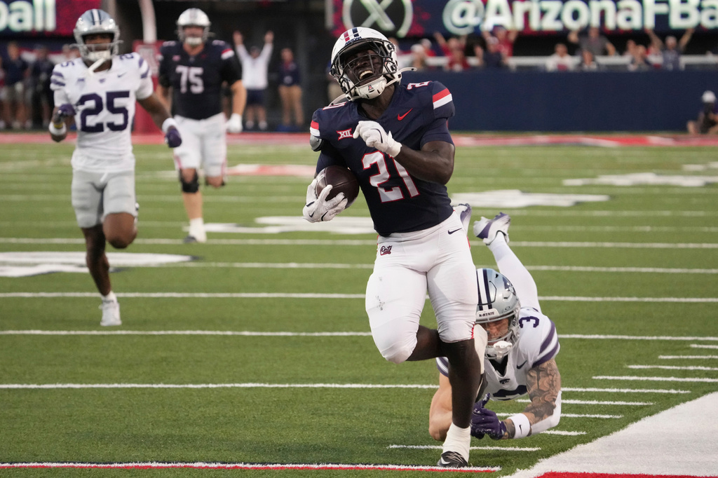 FILE - Arizona running back Ismail Mahdi (21) runs away from Kansas State safety Gunner Maldonado (3) in the first half during an NCAA college football game, Sept 12, 2025, in Tucson, Ariz. (AP Photo/Rick Scuteri, File)