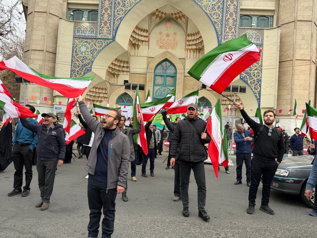 A group of men wave Iranian flags as they attend a demonstration in support of the government and against U.S. and Israeli strikes in Tehran, Iran, Saturday, Feb. 28, 2026. (AP Photo/Vahid Salemi)