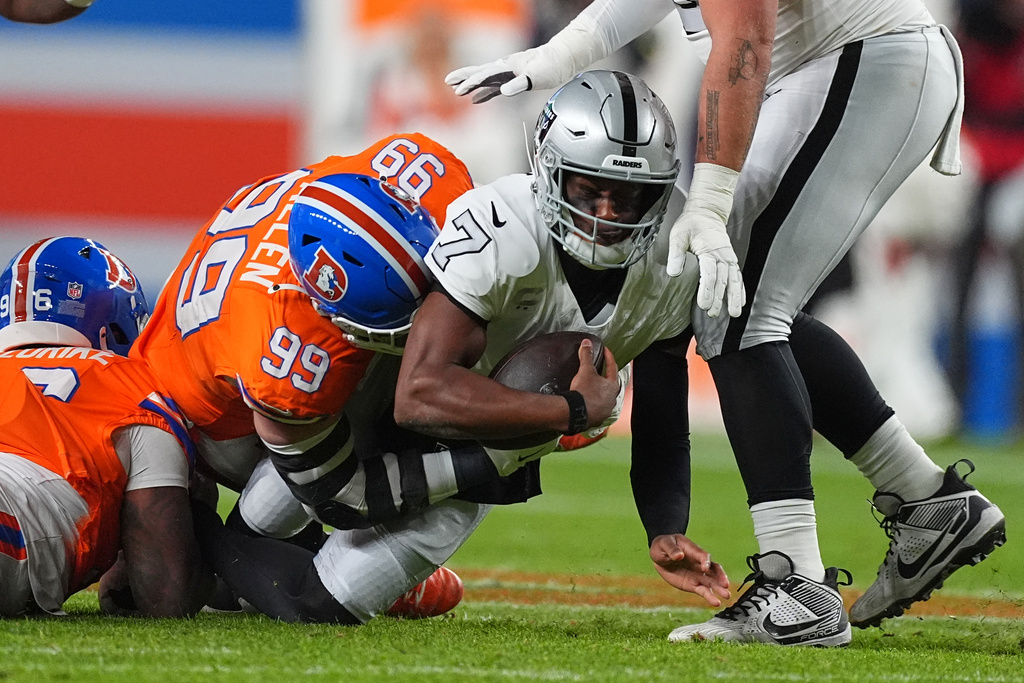 Denver Broncos defensive lineman Zach Allen (99) sacks Las Vegas Raiders quarterback Geno Smith (7) during the first half of an NFL football game Thursday, Nov. 6, 2025, in Denver. (AP Photo/David Zalubowski)
