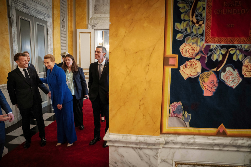 Prime Minister Mette Frederiksen, enter left, and French President Emmanuel Macron, left, laugh before the start of an informal summit in the Danish parliament at Christiansborg Castle in Copenhagen on Wednesday, Oct. 1, 2025. (Mads Claus Rasmussen/Ritzau Scanpix via AP)