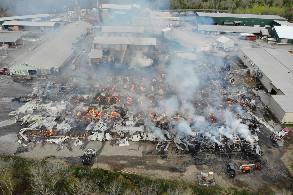 In this photo provided by the Maine State Fire Marshal, flames burn through Robbins Lumber following an explosion, May 15, 2026, in Searsmont, Maine. (Maine State Fire Marshal via AP)