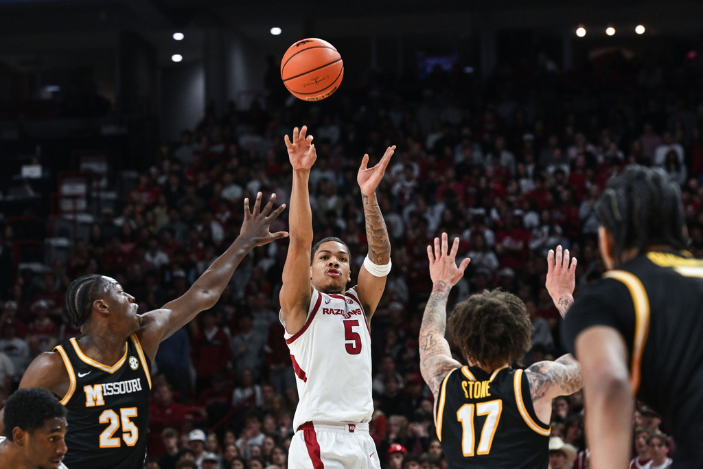 Arkansas guard Darius Acuff Jr. (5) shoots a three pointer over Missouri defenders Mark Mitchell (25) and Jayden Stone (17) during an NCAA college basketball game Saturday, Feb. 21, 2026, in Fayetteville, Ark. (AP Photo/Michael Woods)