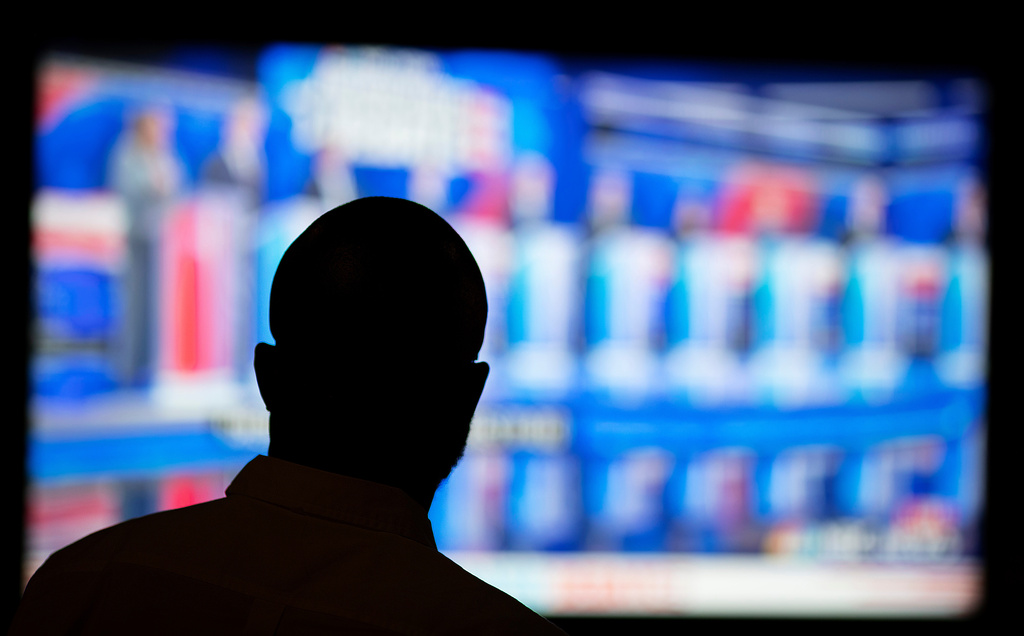 FILE - Offei Koram watches a broadcast of a Democratic presidential debate at a bar in Atlanta, June 27, 2019. (AP Photo/David Goldman, File)