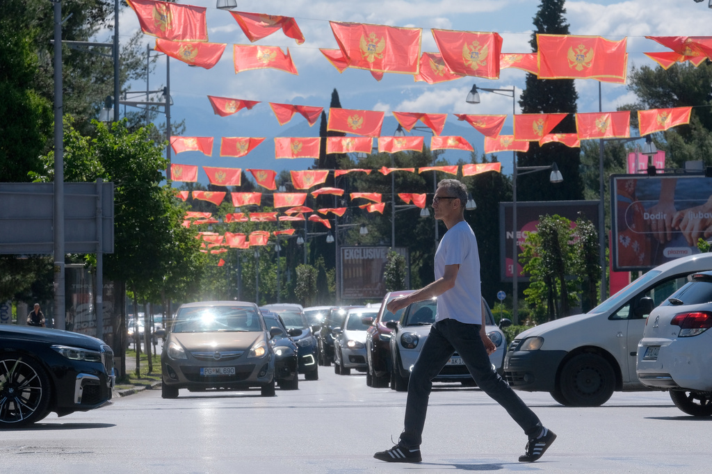 A man walks on a street decorated with national flags in Montenegro's capital Podgorica, Monday, May 18, 2026. (AP Photo/Risto Bozovic)