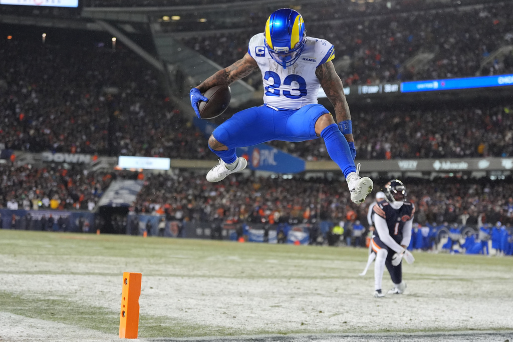 Los Angeles Rams running back Kyren Williams, front, scores a touchdown after evading a tackle by Chicago Bears cornerback Jaylon Johnson during the second half of an NFL football divisional playoff game Sunday, Jan. 18, 2026, in Chicago. (AP Photo/Jeff Roberson)