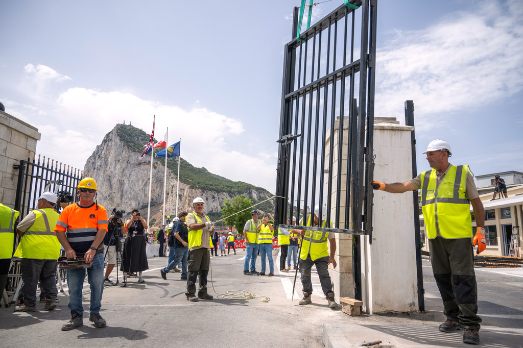 Workers remove the fence separating the disputed British overseas territory from Spain on the first day of passport-free travel under a new EU-U.K. treaty, at the border crossing between Gibraltar and Spain in La Línea de la Concepción, Spain, Wednesday, July 15, 2026. (AP Photo/Marcos Moreno)