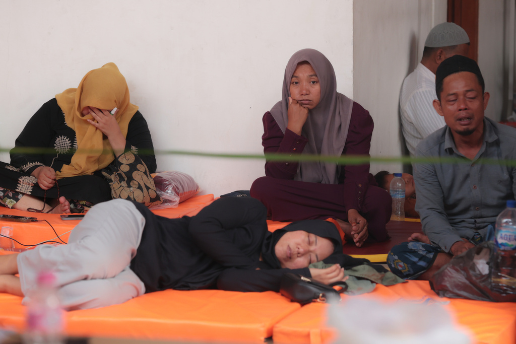 People wait as rescue work is underway after a building under construction collapsed at an Islamic boarding school in Sidoarjo, East Java, Indonesia, Tuesday, Sept. 30, 2025. (AP Photo/Trisnadi)