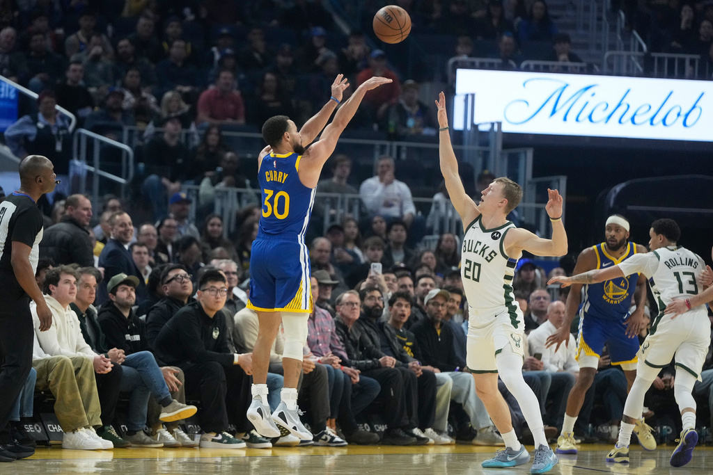 Golden State Warriors guard Stephen Curry (30) shoots against a 3-point basket against Milwaukee Bucks guard AJ Green (20) during the first half of an NBA basketball game in San Francisco, Wednesday, Jan. 7, 2026. (AP Photo/Jeff Chiu)