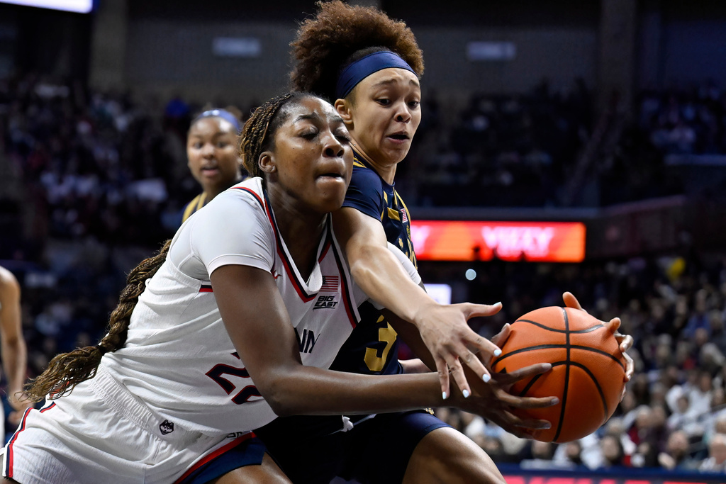 UConn forward Serah Williams, left, is pressured by Notre Dame guard Hannah Hidalgo, right, in the first half of an NCAA college basketball game, Monday, Jan. 19, 2026, in Storrs, Conn. (AP Photo/Jessica Hill)