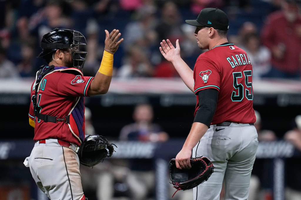 Arizona Diamondbacks catcher Gabriel Moreno, left, and pitcher Brandyn Garcia (55) celebrate after the Diamondbacks defeated the Guardians in a baseball game in Cleveland, Friday, July 31, 2026. (AP Photo/Sue Ogrocki)