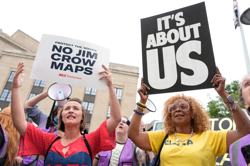 Mandy Cook, left, and Cheryl Woodard, hold signs during a rally against a special session of the state legislature to redraw U.S. Congressional voting maps Tuesday, May 5, 2026, in Nashville, Tenn. (AP Photo/George Walker IV)