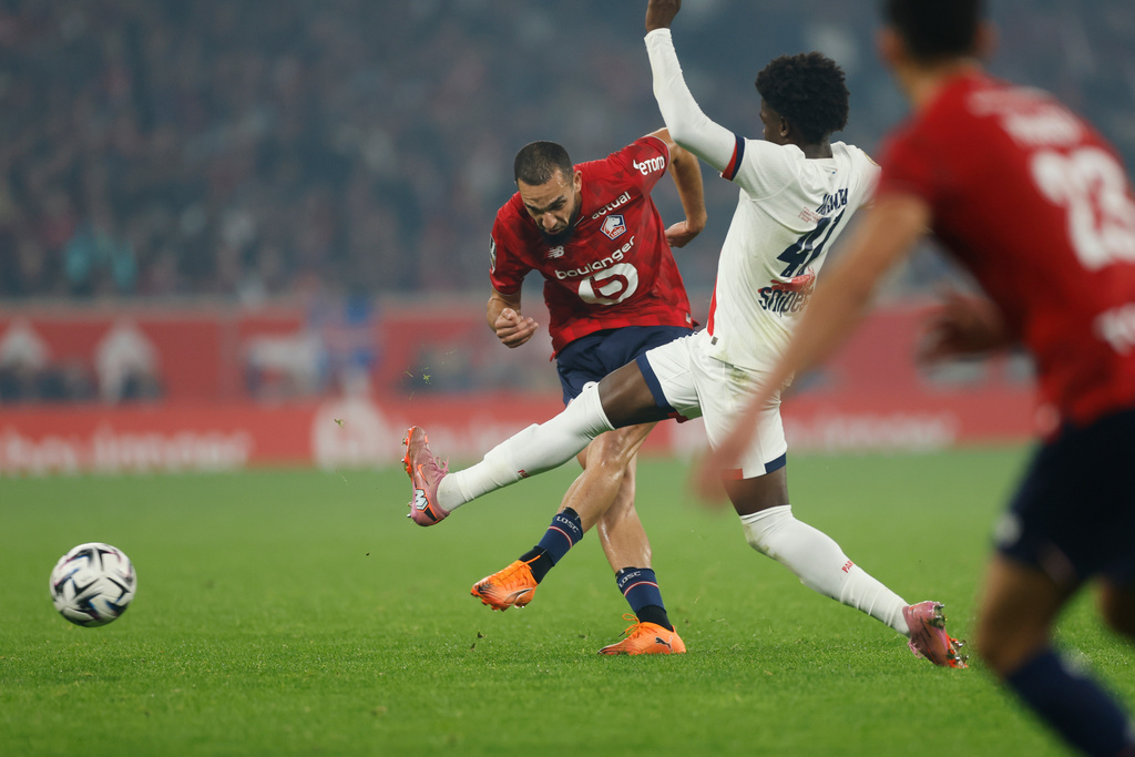 Lille's Nabil Bentaleb, left, an PSG's Quentin Ndjantou challenge for the ball during the French League One soccer match between Lille and Paris Saint-Germain at the Stade Pierre-Mauroy in Villeneuve-d'Ascq, outside Lille, France, Sunday, Oct. 5, 2025. (AP Photo/Jean-Francois Badias)