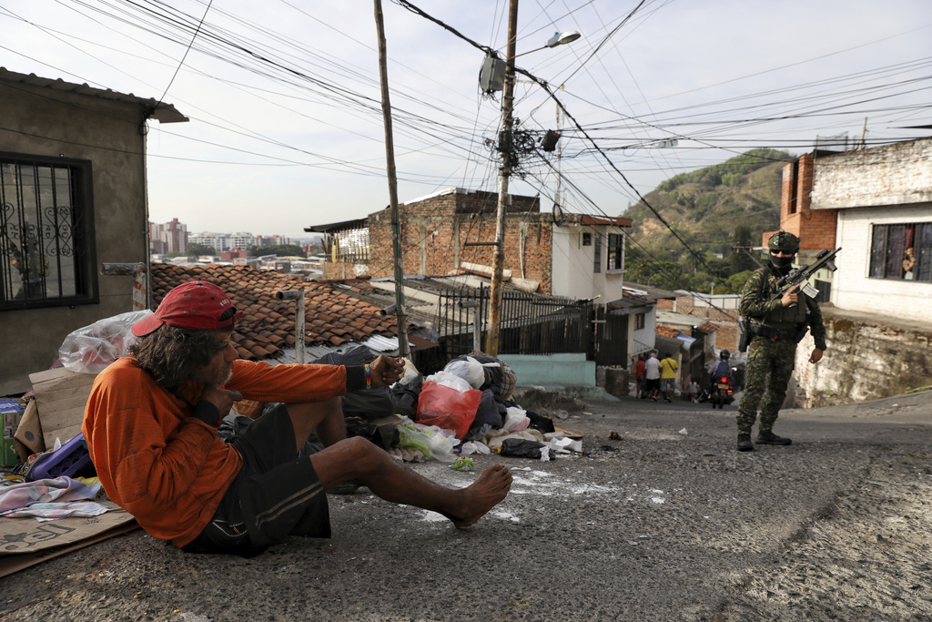 A man mocks a soldier patrolling the Siloé neighborhood in Cali, Colombia, Thursday, Sept. 11, 2025. (AP Photo/Santiago Saldarriaga)