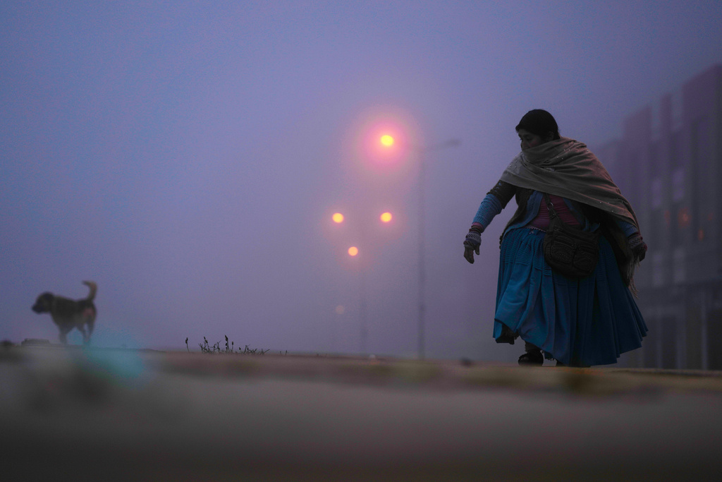 A woman walks before the opening of polls for a presidential runoff election in El Alto, Bolivia, Sunday, Oct. 19, 2025. (AP Photo/Natacha Pisarenko)