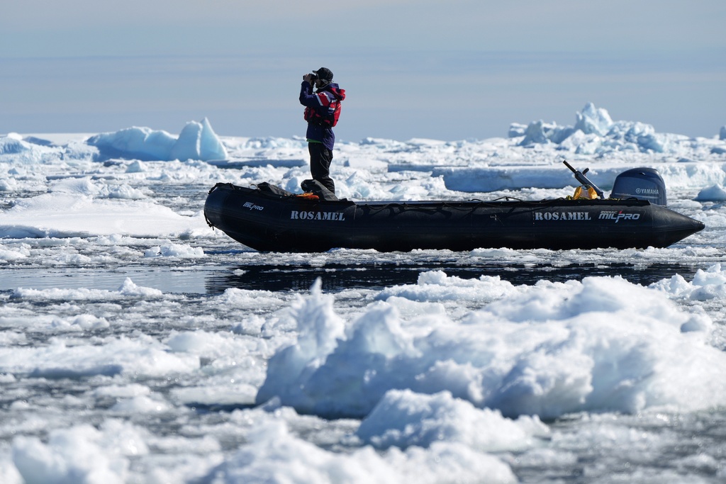 A crew member looks for whales at Yalour Islands in Antarctica, Monday, Nov. 24, 2025. (AP Photo/Mark Baker)