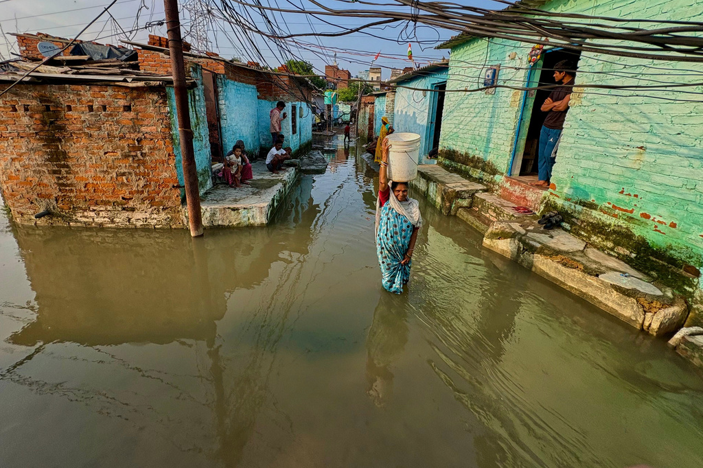 A woman wades through floodwaters in her neighborhood following heavy rains in Kanpur, India, on Sept. 22, 2026. (AP Photo)