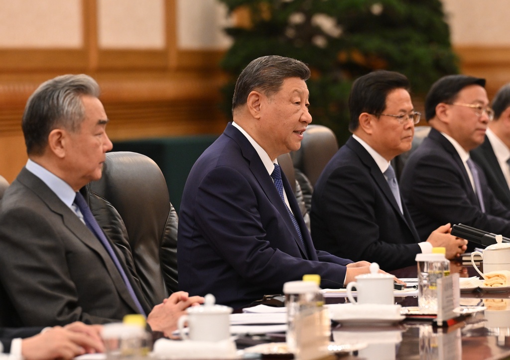 China's President Xi Jinping, center, speaks to France's President Emmanuel Macron, unseen, next to China's Foreign Minister Wang Yi during a bilateral meeting at the Great Hall of the People in Beijing, Thursday, Dec. 4, 2025. (Adek Berry/Pool Photo via AP)