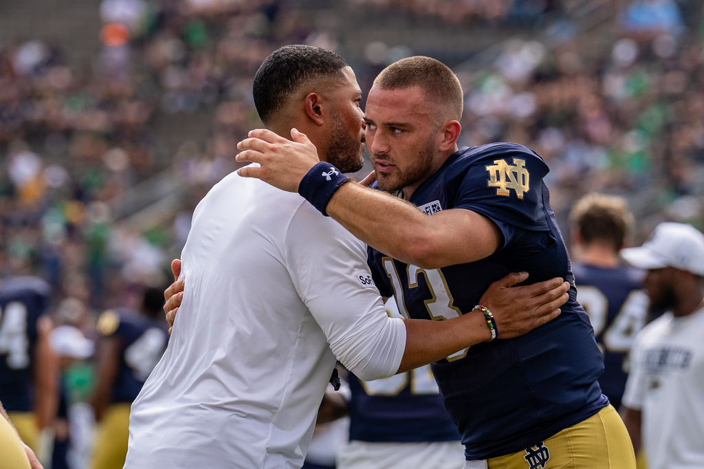 Notre Dame head coach Marcus Freeman embraces quarterback CJ Carr before an NCAA college football game against Rice, Saturday, Sept. 12, 2026, in South Bend, Ind. (AP Photo/Paul Barnick)