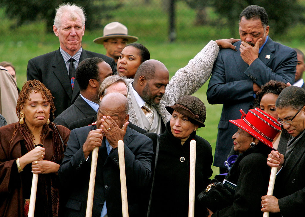 FILE - The Rev. Jesse Jackson, top right, is consoled by Rev. Marvin Winans, as Martin Luther King Jr.'s daughter Yolanda King, front from left, civil rights leader Rep. John Lewis, D-Ga., wiping his tears, former Labor Secretary Alexis Herman, Martin Luther King Jr.'s sister Christine King Farris and Darryl R. Matthews, President of the Alpha Phi Alpha Fraternity and Bill Walton, top left, take part in the ground breaking ceremony for the Martin Luther King Jr. Memorial on the National Mall, Nov. 13, 2006 in Washington. (AP Photo/Evan Vucci, File)