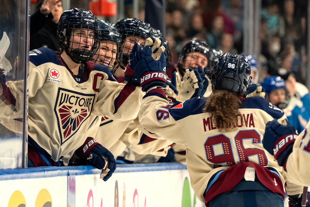 Montreal Victoire's Marie-Philip Poulin (29) celebrates with Natalie Mlynkova (96) after Mlýnková's goal against the Vancouver Goldeneyes during the second period of a PWHL hockey game in Vancouver, British Columbia, Saturday, Dec. 20, 2025. (Ethan Cairns/The Canadian Press via AP)