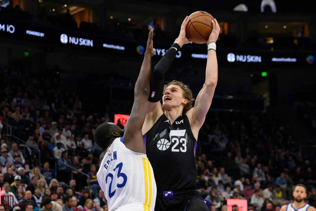 Utah Jazz forward Lauri Markkanen (23) shoots over Golden State Warriors forward Draymond Green (23) during the first half of an NBA basketball game, Wednesday, Jan. 28, 2026, in Salt Lake City. (AP Photo/Tyler Tate)