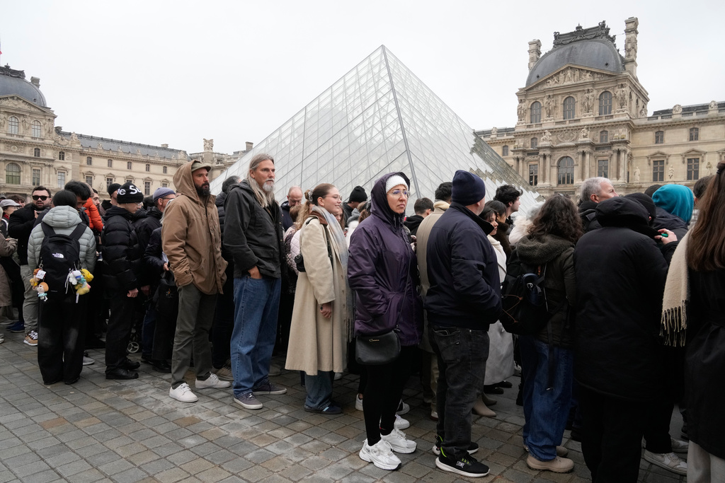 People queue outside the Louvre museum, in Paris, France, Friday, Feb. 13, 2026. (AP Photo/Michel Euler)