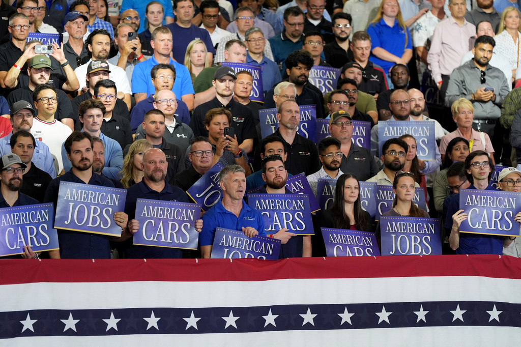 Attendees listen as President Donald Trump speaks at General Motors proving ground, Monday, July 27, 2026, in Milford, Mich. (AP Photo/Alex Brandon)