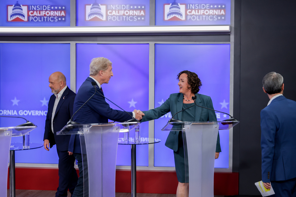 Tom Steyer, center left, and Katie Porter, candidates in California's gubernatorial race, shake hands during a debate Wednesday, April 22, 2026, in San Francisco. (Jason Henry/Pool Photo via AP)