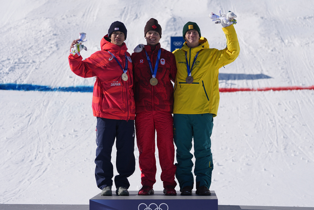 From left, silver medalist Japan's Ikuma Horishima (2), gold medalist Canada's Mikael Kingsbury (4), and bronze medalist Australia's Matt Graham (6) celebrate after the men's freestyle skiing dual moguls finals at the 2026 Winter Olympics, in Livigno, Italy, Sunday, Feb. 15, 2026. (AP Photo/Gregory Bull)