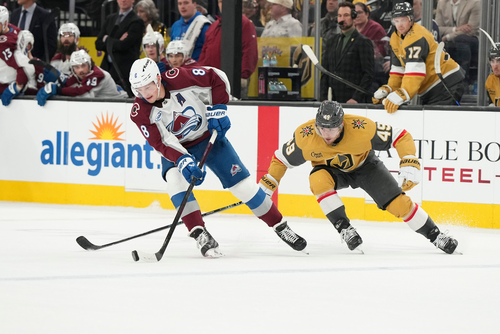 Colorado Avalanche defenseman Cale Makar (8) skates with the puck against Vegas Golden Knights left wing Ivan Barbashev (49) during the second period of an NHL hockey game, Saturday, Dec. 27, 2025, in Las Vegas. (AP Photo/Candice Ward)
