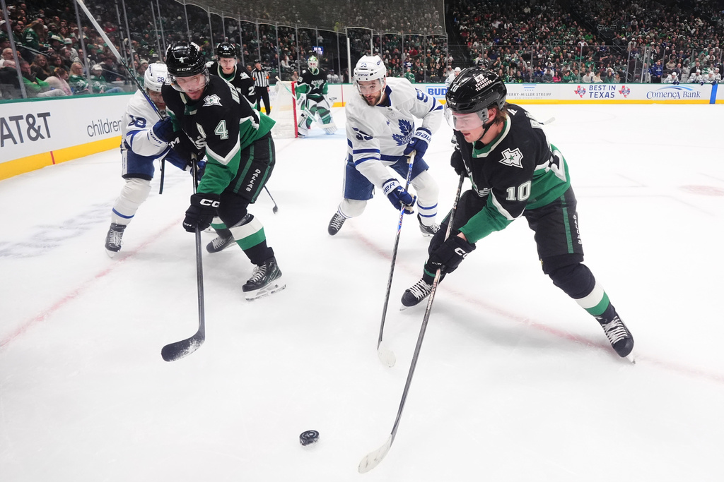 Dallas Stars center Oskar Bäck (10) and defenseman Miro Heiskanen (4) skate for the puck against Toronto Maple Leafs center Nicolas Roy (55) and right wing William Nylander (88) during the second period of an NHL hockey game Sunday, Dec. 21, 2025, in Dallas. (AP Photo/LM Otero)