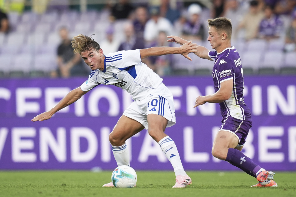Como's Nicolas Paz, left, fights for the ball with Fiorentina's Hans Nicolussi Caviglia during the Italian Serie A soccer match between Fiorentina and Como at the Artemio Franchi Stadium in Florence, Italy, Sunday, Sept. 21, 2025. (Massimo Paolone/LaPresse via AP)