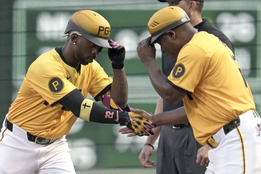 Pittsburgh Pirates' Andrew McCutchen, left, celebrates with first base coach Tarrik Brock, after hitting a single off Athletics pitcher Luis Severino during the first inning of a baseball game in Pittsburgh, Friday, Sept. 19, 2025. (AP Photo/Gene J. Puskar)