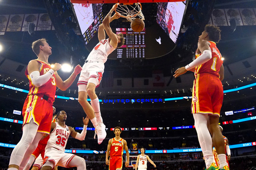 Chicago Bulls forward Matas Buzelis, center, dunks the ball on Atlanta Hawks guard Luke Kennard, left, and forward Jalen Johnson during the second half of an NBA basketball game Monday, Oct. 27, 2025, in Chicago. (AP Photo/David Banks) Chicago Bulls forward Matas Buzelis, center, dunks the ball on Atlanta Hawks guard Luke Kennard, left, and forward Jalen Johnson during the second half of an NBA basketball game Monday, Oct. 27, 2025, in Chicago. (AP Photo/David Banks)